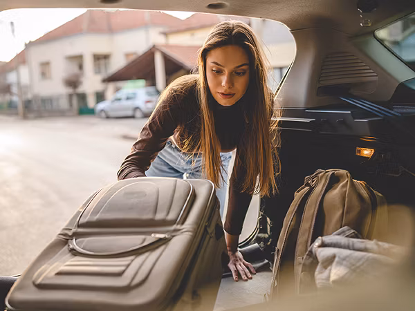 Person unpacking luggage from car