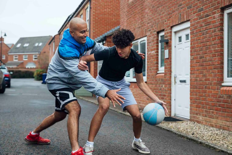 Two people playing a friendly game of basketball