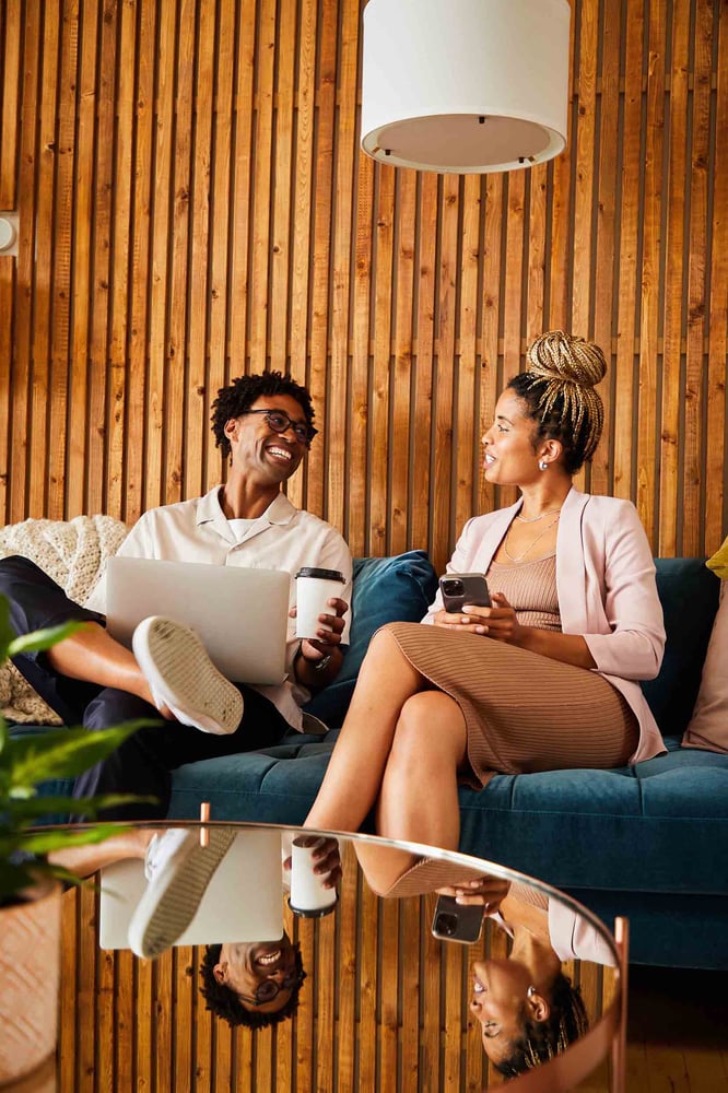 Two students smiling on a couch