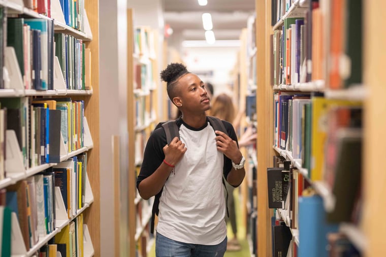 student searching for a book in a library