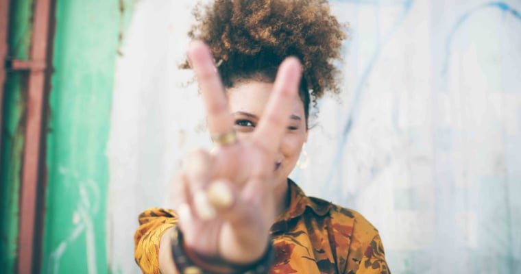 Person giving the peace sign to camera